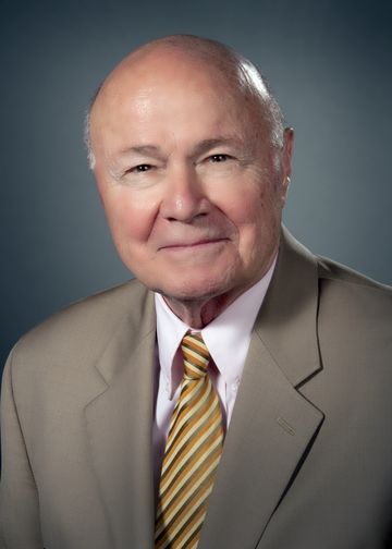 Ralph Nappi wearing a tan suit and gold tie